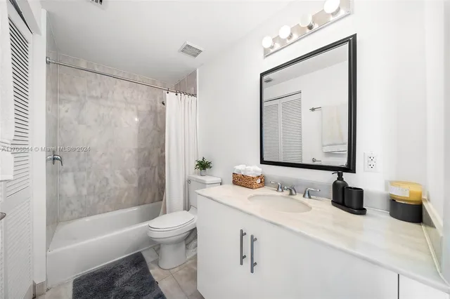 a bathroom with a bathtub shower sink vanity and toilet