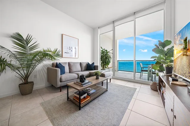 a living room with furniture a couch and a potted plant