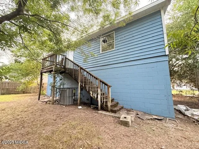 a view of a house with a yard and wooden fence