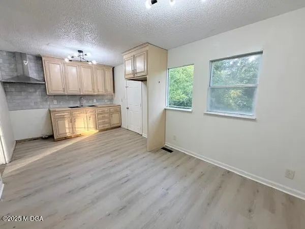 a large kitchen with a wooden floor and a window