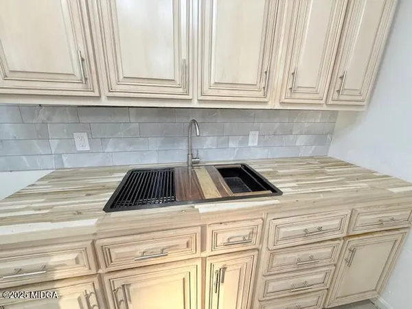 a kitchen with granite countertop white cabinets and appliances