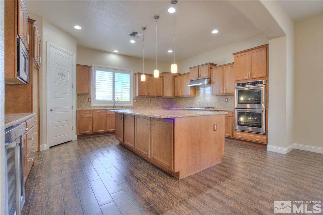 9800 Shadowless Trail Reno, NV 89521 - Photo 12 of 36 a kitchen with stainless steel appliances granite countertop a refrigerator a sink dishwasher and a oven with wooden floors