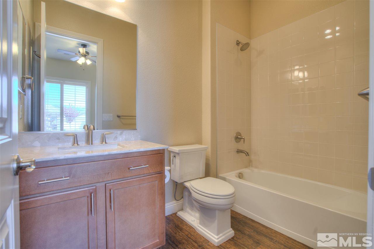 9800 Shadowless Trail Reno, NV 89521 - Photo 23 of 36 a bathroom with a granite countertop sink a toilet and shower
