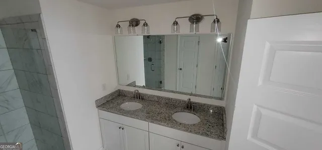 a bathroom with a granite countertop sink and a mirror