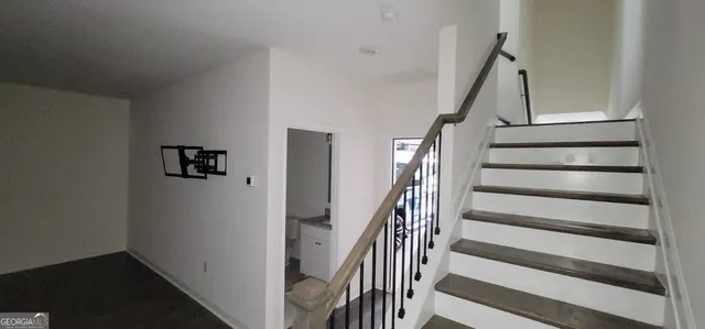 a view of staircase with wooden floor and white walls