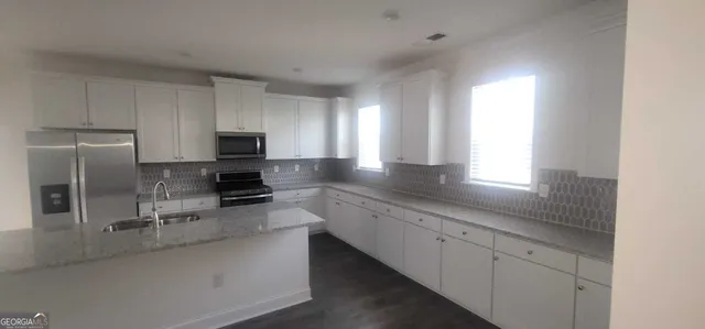 a large kitchen with a large window and stainless steel appliances