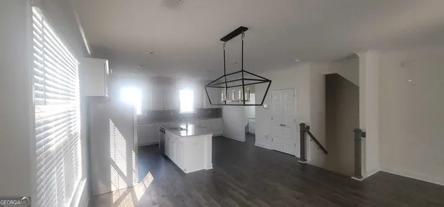 a view of a hallway with wooden floor and a chandelier
