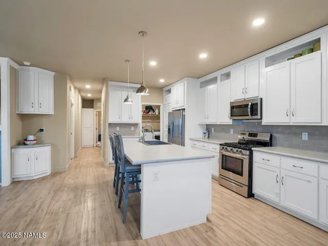 a kitchen with white cabinets stainless steel appliances and sink