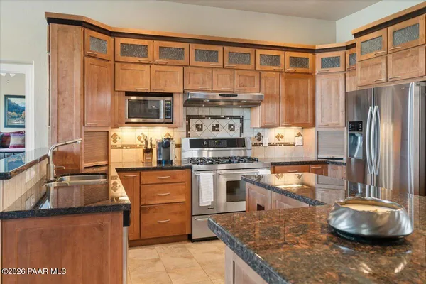 a kitchen with stainless steel appliances granite countertop a sink stove and refrigerator