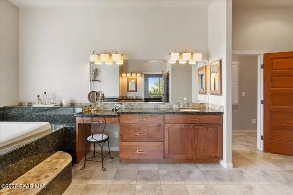 a spacious bathroom with a granite countertop sink and a mirror