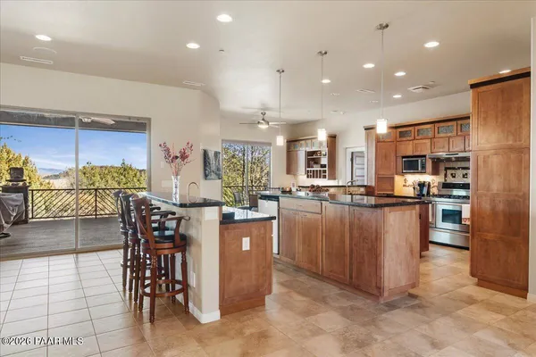 a kitchen with stainless steel appliances kitchen island granite countertop a table and chairs