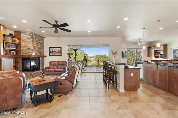 a living room with furniture a fireplace and a kitchen view