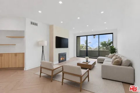 a living room with furniture a flat screen tv and a large window