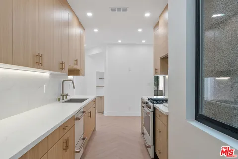 a kitchen with a sink stove and cabinets