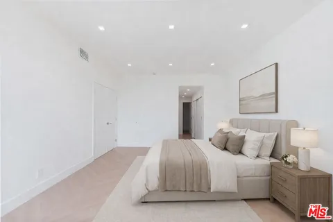 a bedroom with a bed and a night stand