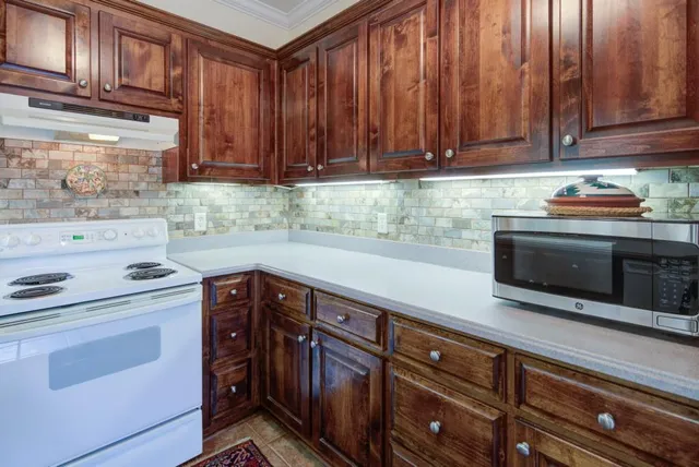a kitchen with stainless steel appliances granite countertop a sink stove and cabinets