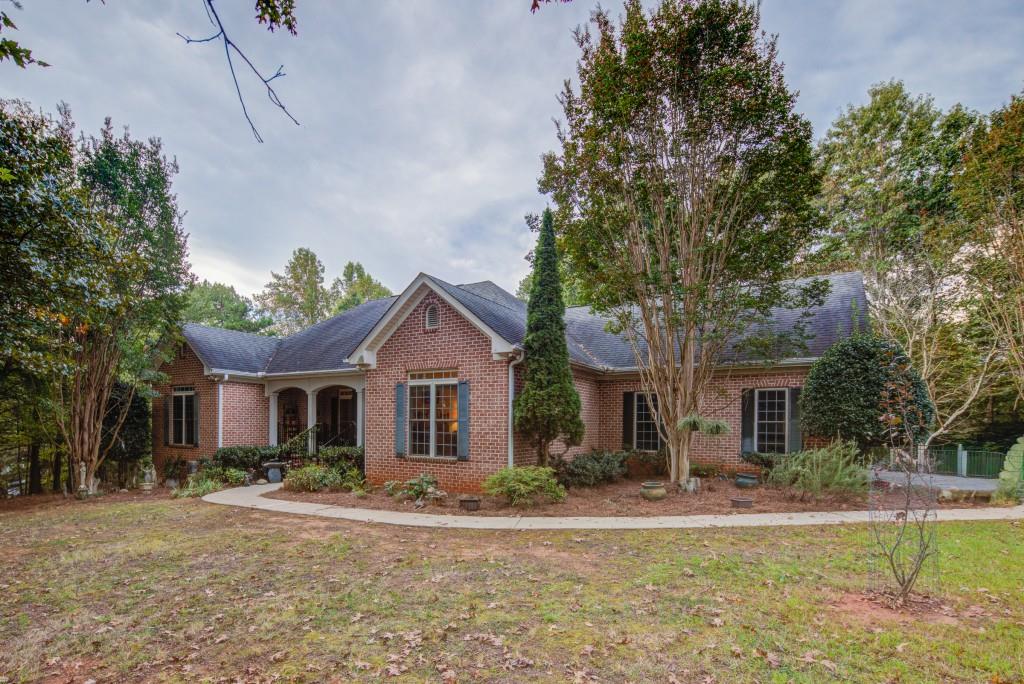 1170 Calhoun Road Dahlonega, GA 30533 - Photo 5 of 34 a front view of a house with a garden and tree