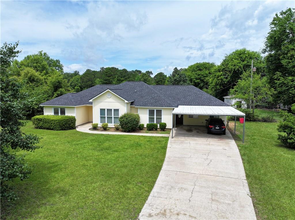 280 Owens Road Fort Mitchell, AL 36856 - Photo 56 of 56 Ranch-style home featuring concrete driveway, a front lawn, a shingled roof, a carport, and board and batten siding