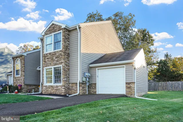 a view of a house with a yard and pathway