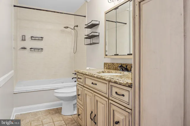 a bathroom with a granite countertop sink toilet and shower