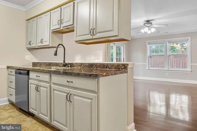 a kitchen with stainless steel appliances granite countertop a sink and cabinets with wooden floor