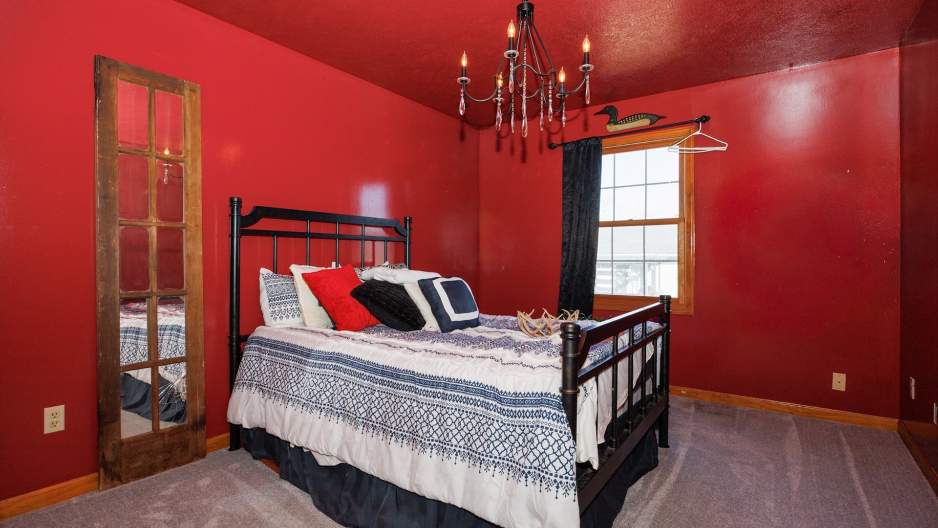 67 Oak Park Road Bloomington, IL 61701 - Photo 17 of 34 a bedroom with a bed and a chandelier