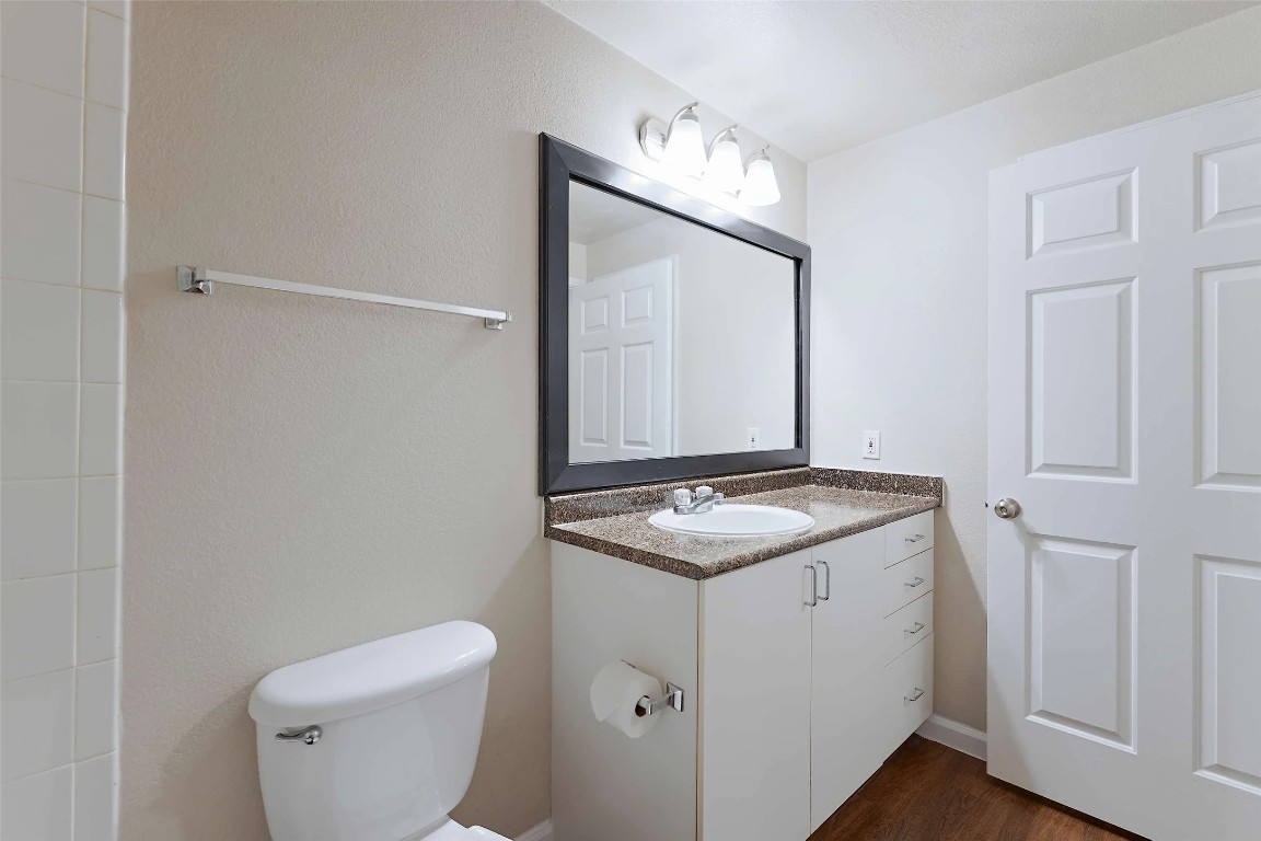 10505 South I-35 Frontage Road, Unit 222 Austin, TX 78747 - Photo 16 of 25 a bathroom with a granite countertop sink and a toilet