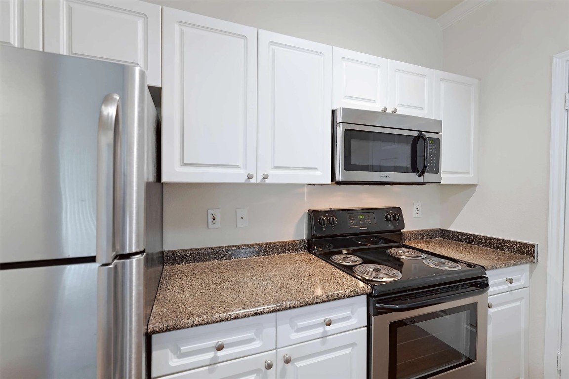 10505 South I-35 Frontage Road, Unit 222 Austin, TX 78747 - Photo 8 of 25 a kitchen with granite countertop a sink stove and microwave