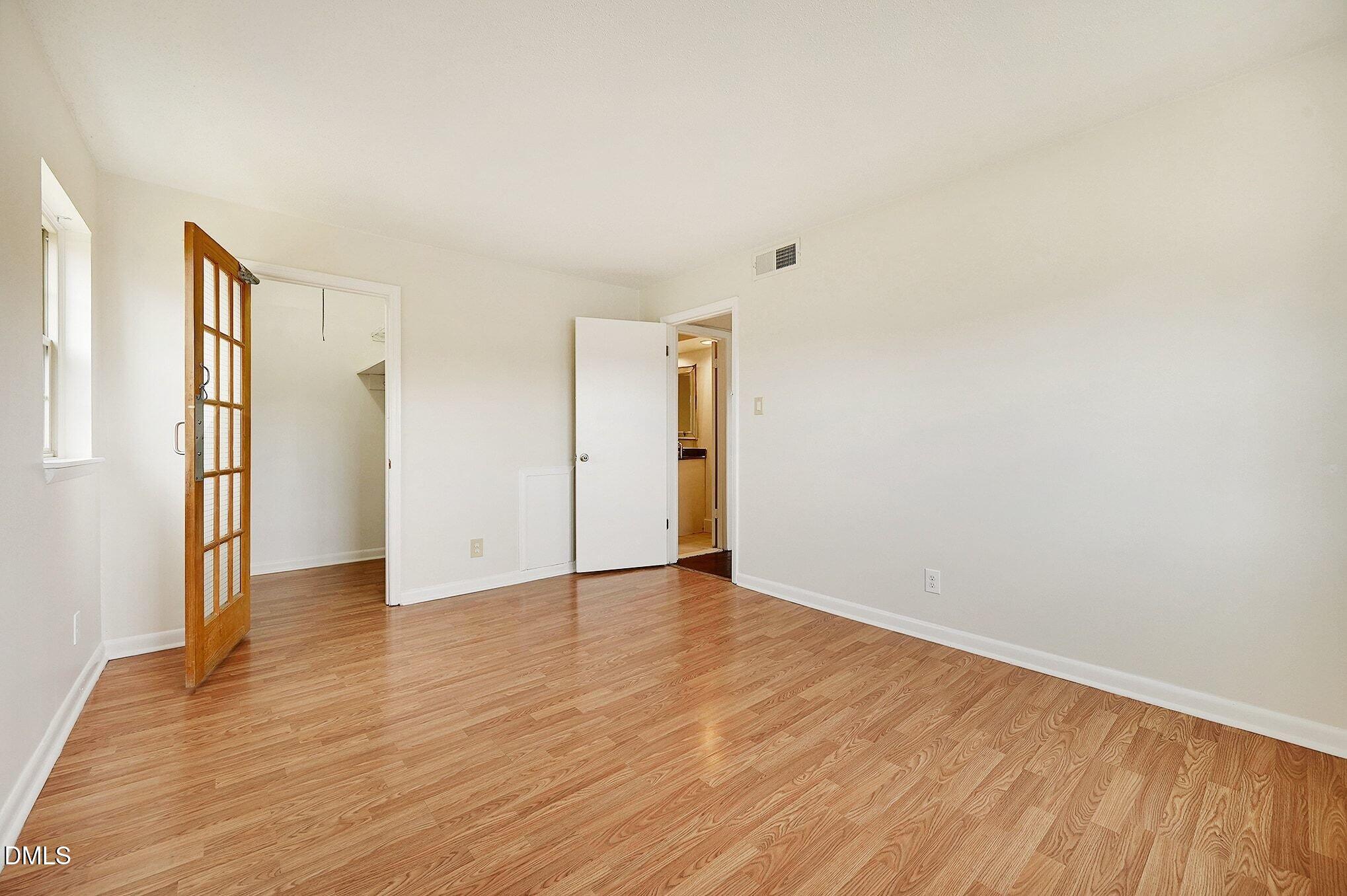 501 Jones Ferry Road, Unit N9 Carrboro, NC 27510 - Photo 9 of 22 a view of an empty room with wooden floor and a window
