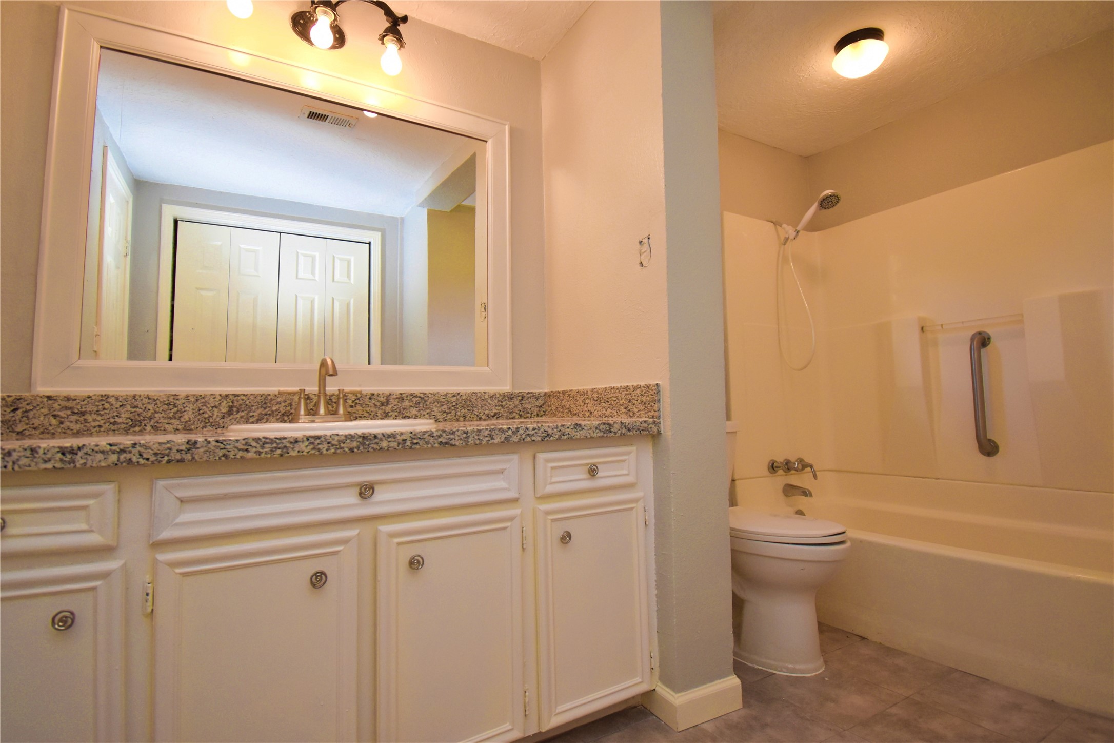 1115 Georgina Street Rosenberg, TX 77471 - Photo 13 of 17 a bathroom with a granite countertop toilet a sink and bathtub