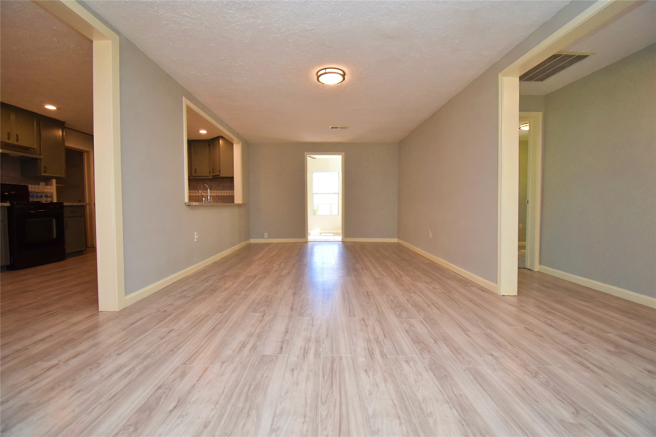 1115 Georgina Street Rosenberg, TX 77471 - Photo 5 of 17 a view of an empty room with wooden floor and a window