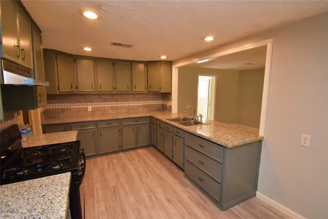 a kitchen with a sink stove and cabinets