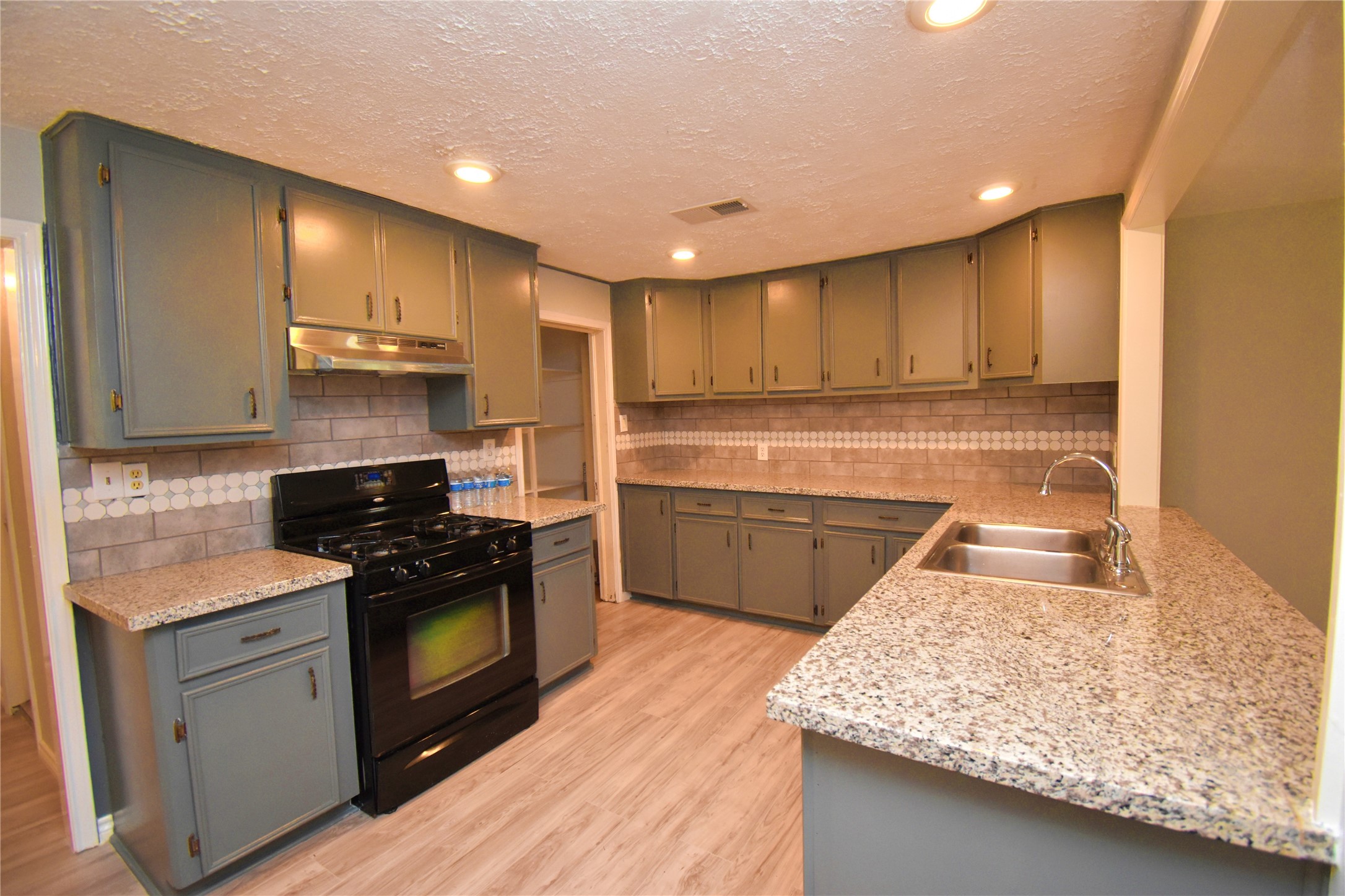 1115 Georgina Street Rosenberg, TX 77471 - Photo 7 of 17 a kitchen with stainless steel appliances granite countertop a sink stove and refrigerator