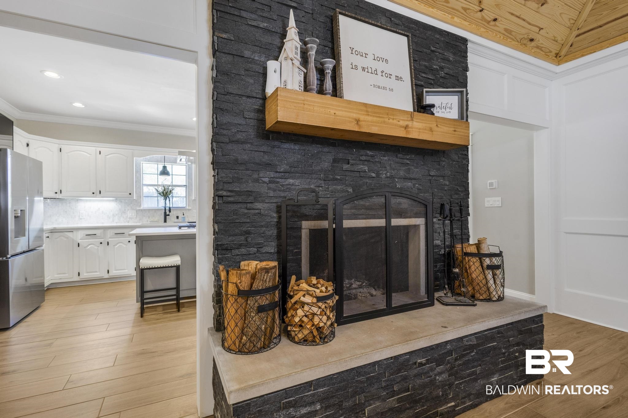 83 Caisson Trace Daphne, AL 36527 - Photo 13 of 63 Stacked stone fireplace with a substantial hearth, wood-finish flooring, and a natural wood mantel