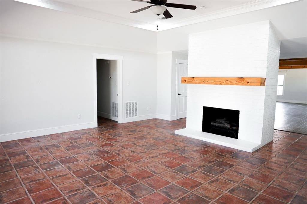 10575 Friendship Road Pilot Point, TX 76258 - Photo 19 of 32 Central white brick fireplace with a wood mantel