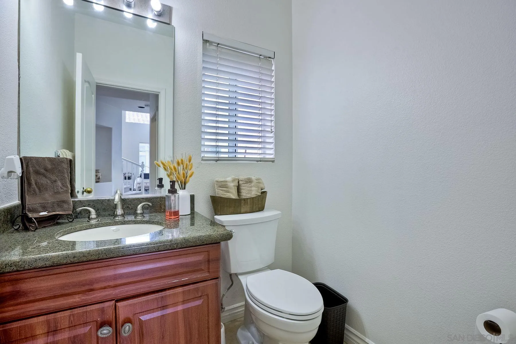 2479 Golfcrest Loop Chula Vista, CA 91915 - Photo 12 of 25 a bathroom with a granite countertop toilet sink and mirror