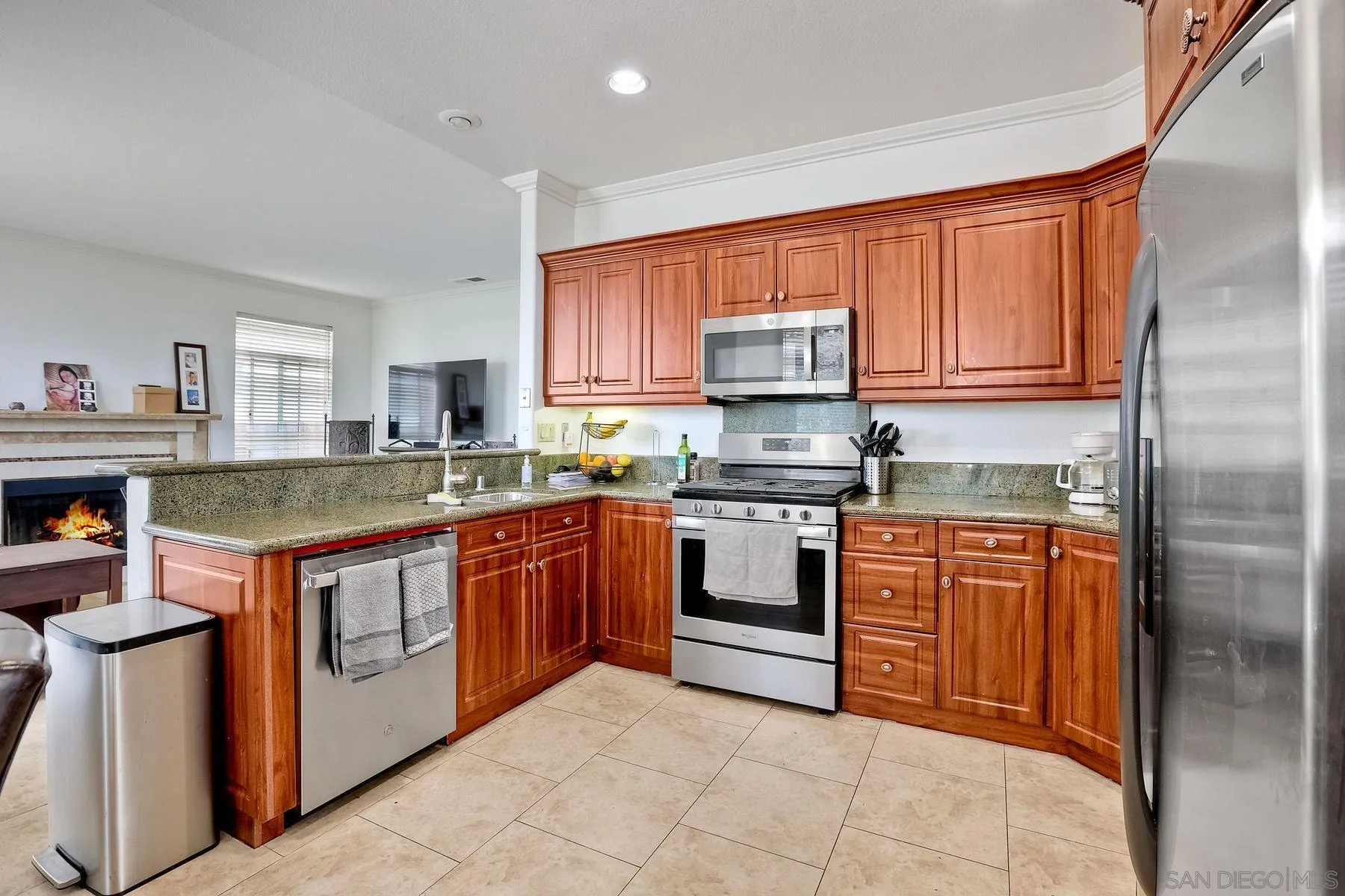 2479 Golfcrest Loop Chula Vista, CA 91915 - Photo 8 of 25 a kitchen with stainless steel appliances granite countertop a stove top oven a sink dishwasher and a stove with wooden cabinets