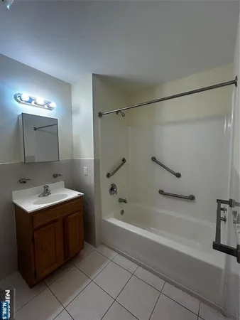 a bathroom with a tub sink and mirror