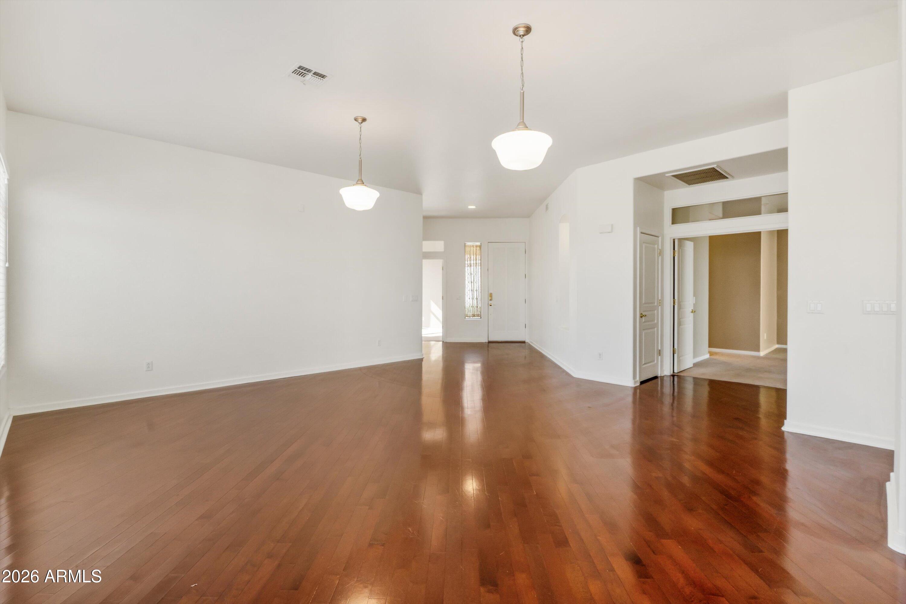 2130 East Beautiful Lane Phoenix, AZ 85042 - Photo 12 of 35 a view of an empty room with wooden floor and windows