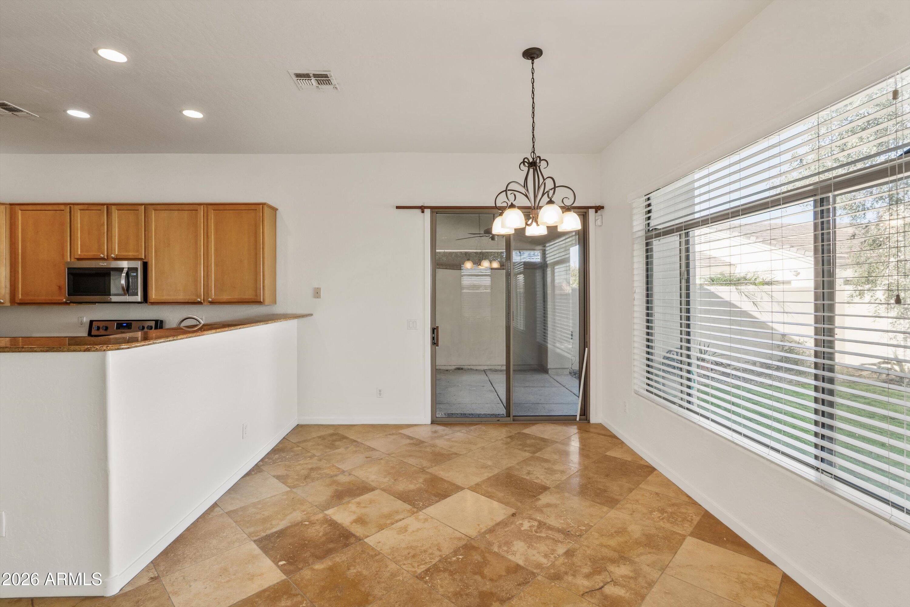 2130 East Beautiful Lane Phoenix, AZ 85042 - Photo 15 of 35 a view of a kitchen with kitchen island granite countertop stainless steel appliances cabinets and a counter top space