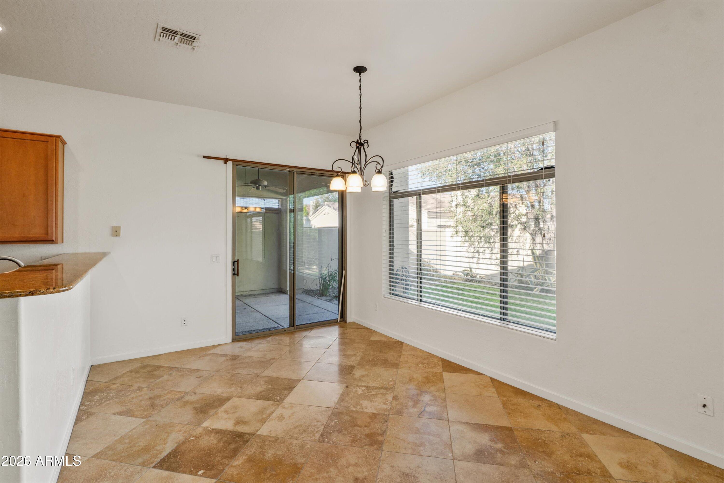 2130 East Beautiful Lane Phoenix, AZ 85042 - Photo 16 of 35 a view of an empty room with chandelier fan and windows