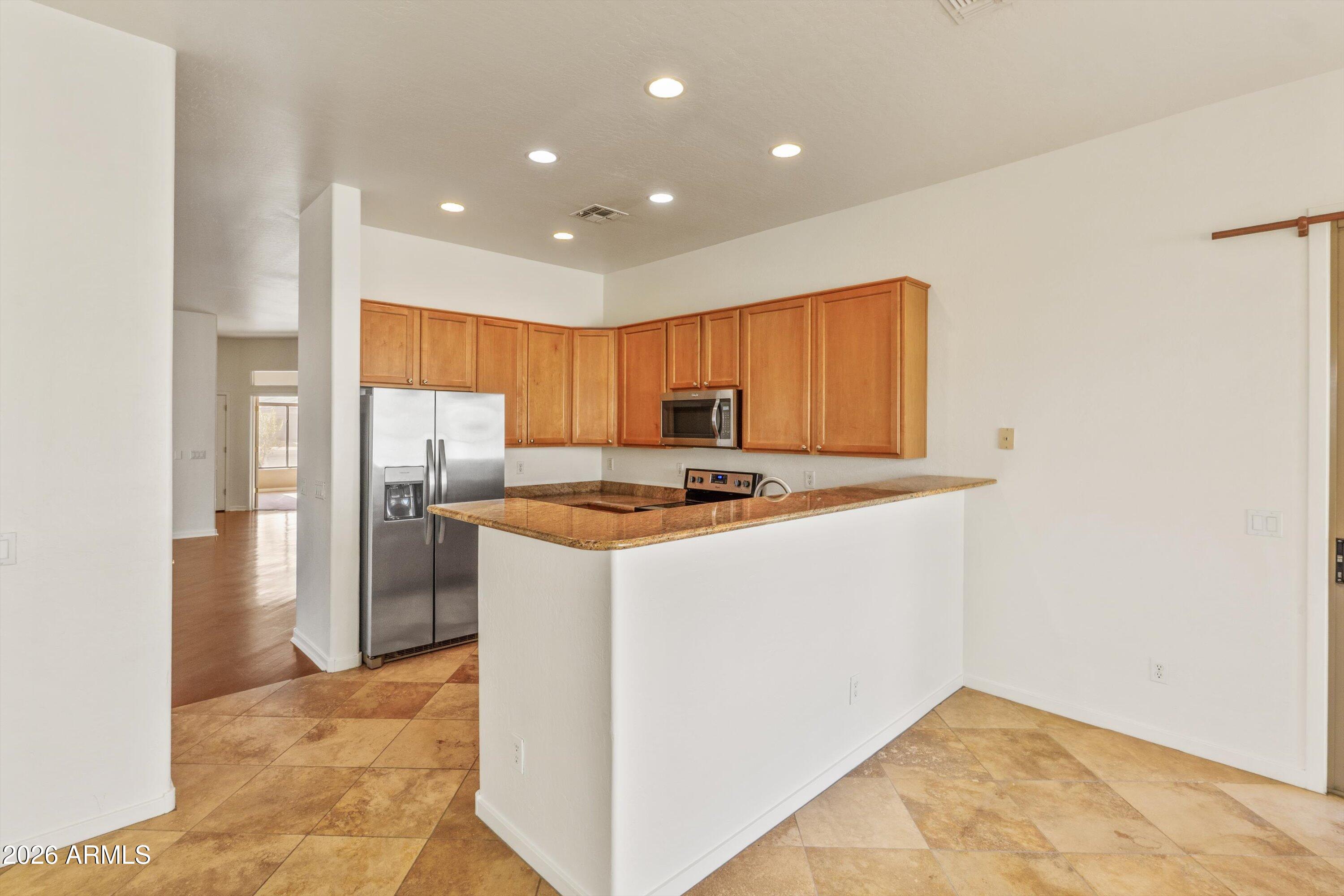 2130 East Beautiful Lane Phoenix, AZ 85042 - Photo 18 of 35 a kitchen with stainless steel appliances granite countertop a refrigerator and a stove top oven