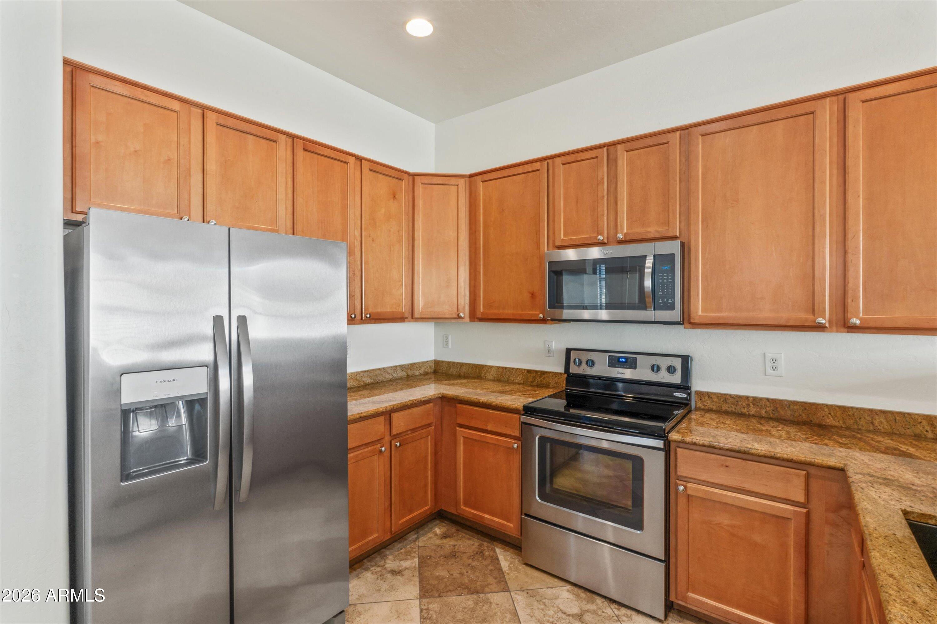 2130 East Beautiful Lane Phoenix, AZ 85042 - Photo 20 of 35 a kitchen with granite countertop a refrigerator stove and microwave