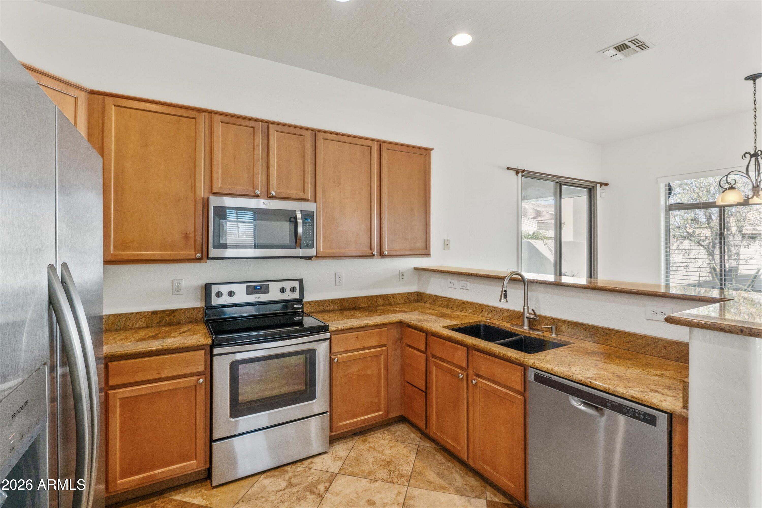 2130 East Beautiful Lane Phoenix, AZ 85042 - Photo 21 of 35 a kitchen with granite countertop a sink stainless steel appliances and cabinets