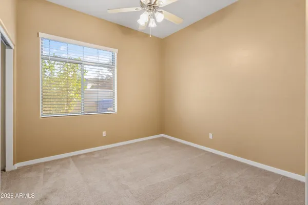 an empty room with a window and a fan