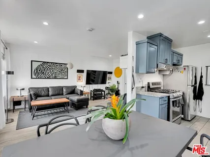 a living room with furniture a flat screen tv and a table