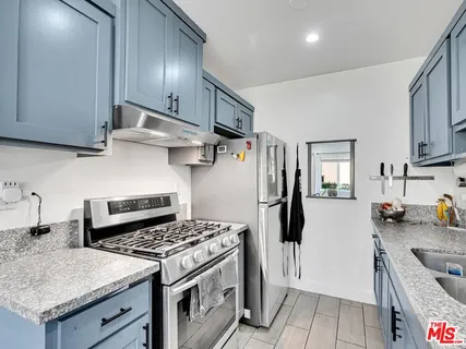 a kitchen with stainless steel appliances granite countertop a stove a refrigerator and a sink