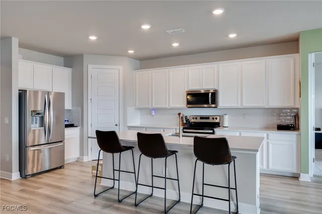 a kitchen with stainless steel appliances a refrigerator stove microwave and cabinets