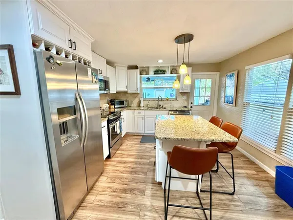 a kitchen with stainless steel appliances granite countertop sink stove and wooden floor