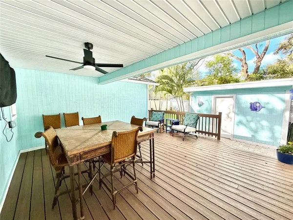 a view of a couches and table in deck with wooden floor